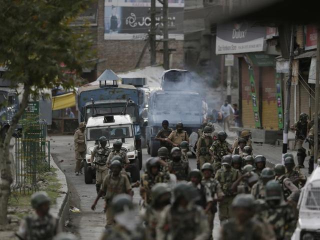 Protesters throw stones on government forces as they walk back towards their camp after a day long curfew in Srinagar.(AP Photo)