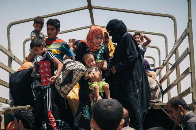 In this Aug. 17, 2016 photo, civilians who recently fled territory formerly controlled by Islamic State militants get off a truck at the Dibaga Camp for displaced people in Hajj Ali. (AP)