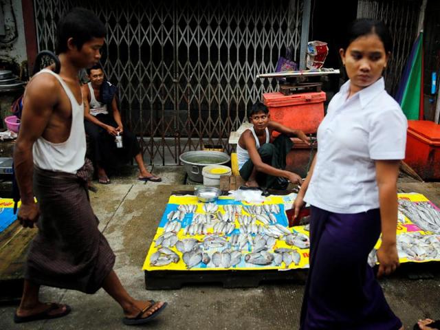 Street vendors past their time while selling fish on a street in central Yangon, Myanmar, on August 22.(REUTERS)