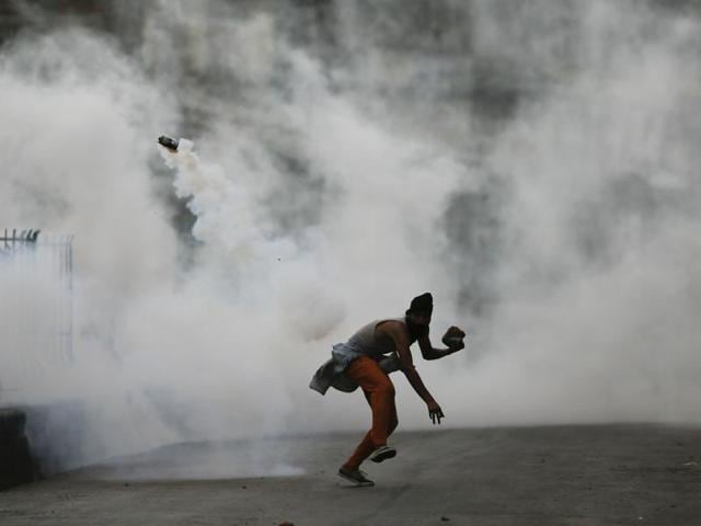 A Kashmiri protester throws a tear smoke shell on government forces in Srinagar, Kashmir. (AP Photo) A Kashmiri protester throws a tear smoke shell on government forces in Srinagar, Kashmir. (AP Photo)