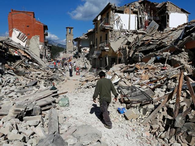 A man walks amidst rubble following an earthquake in Pescara del Tronto. (REUTERS)