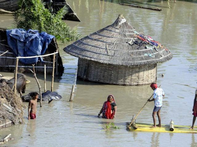 People wade through flood waters on a banana raft in Hajipur, Bihar, on Wednesday.(PTI Photo)