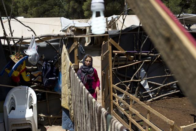 A Syrian woman enters the makeshift courtyard of her family's tent at Ritsona refugee camp, north of Athens, which hosts more than 600 refugees and migrants. (AP Photo) A Syrian woman enters the makeshift courtyard of her family's tent at Ritsona refugee camp, north of Athens, which hosts more than 600 refugees and migrants. (AP Photo)
