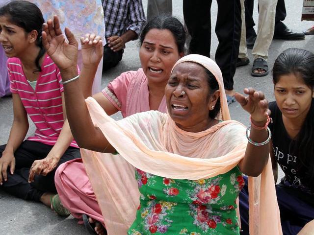 Close relatives of cricketer Abhishek Kumar (inset) protesting against police at Bus Stand Chowk in Patiala on Tuesday.(Bharat Bhushan/HT Photo)