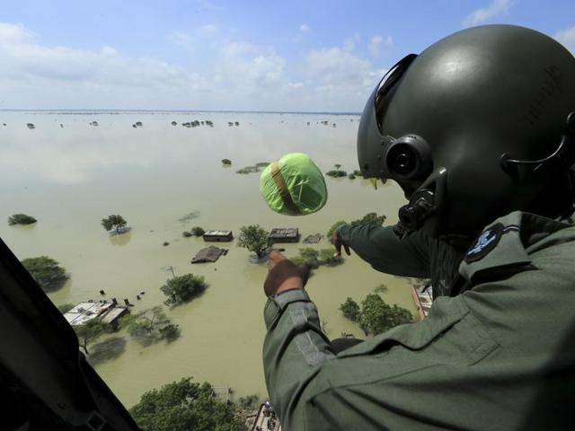 An Indian Air Force official drops relief materials to people affected by floods in Allahabad. (AP/Rajesh Kumar Singh) 