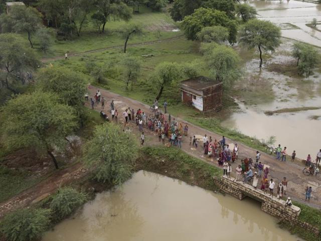 People wait for relief material being distributed by helicopter near Allahabad.  (AP/Rajesh Kumar Singh) 