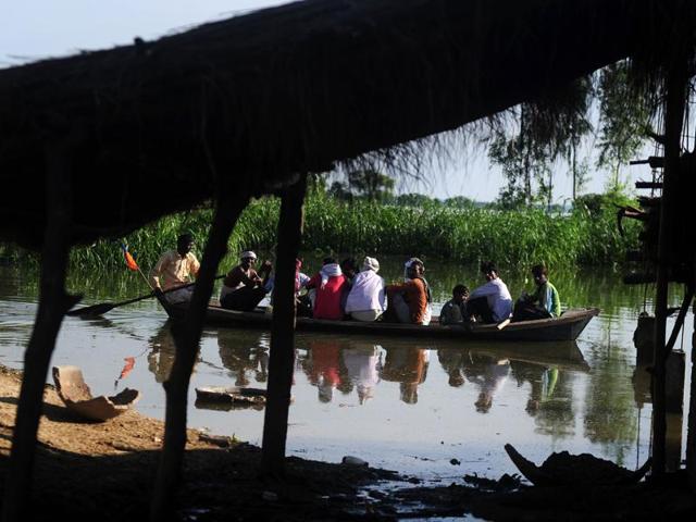 Villagers sit on a boat as they are transported to higher ground after their houses were submerged by the Ganga at Mubarakpur on the outskirts of Allahabad.  (AFP/Sanjay Kanojia) 