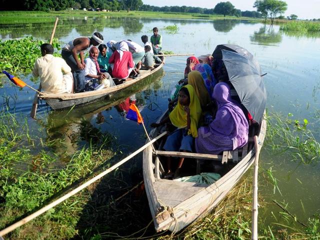 Villagers sit on a boat as they are transported to higher ground after their houses were submerged by the Ganga at Mubarakpur on the outskirts of Allahabad.   (AFP/Sanjay Kanojia) 