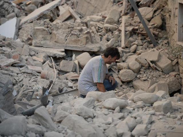 A man reacts to his damaged home after a strong earthquake hit Amatrice. (AFP Photo)