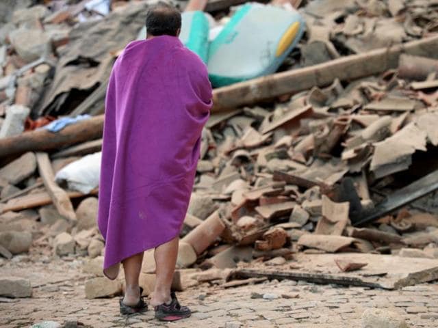 A man stands among the rubble of a house after a strong earthquake hit Amatrice. (AFP Photo)