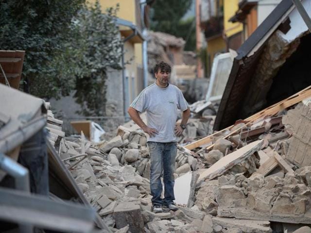 A man stands on a damaged home after a strong earthquake hit Amatrice. Numerous buildings collapsed in small communities close to the epicentre of the quake in a remote, thinly-populated area straddling the regions of Umbria, Marche and Lazio. (AFP Photo)