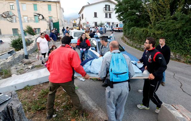 People stand along the road following a quake in Amatrice. (Reuters Photo) People stand along the road following a quake in Amatrice. (Reuters Photo)