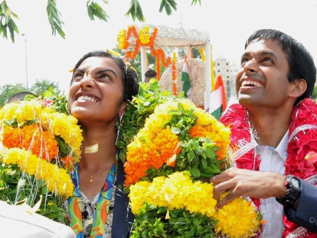 Sindhu and Gopichand acknowledge the crowd as they are welcomed with garlands. (PTI) Sindhu and Gopichand acknowledge the crowd as they are welcomed with garlands. (PTI)