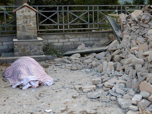 A body is covered by cloth next to rubble following a quake in Amatrice, central Italy. (REUTERS)