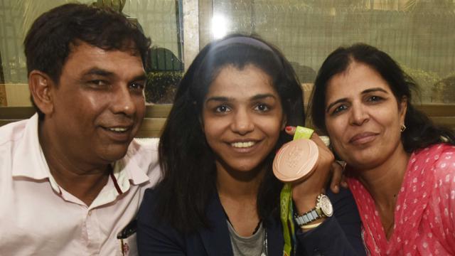 Sakshi Malik savouring her bronze medal with her parents at Haryana state guest house in New Delhi. (Vipin Kumar/HT PHOTO)
