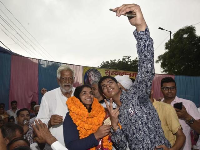 Sakshi Malik takes a selfie with a fan in Tikri Border village on her way to her home town in Rohtak. (Vipin Kumar/HT PHOTO) Sakshi Malik takes a selfie with a fan in Tikri Border village on her way to her home town in Rohtak. (Vipin Kumar/HT PHOTO)