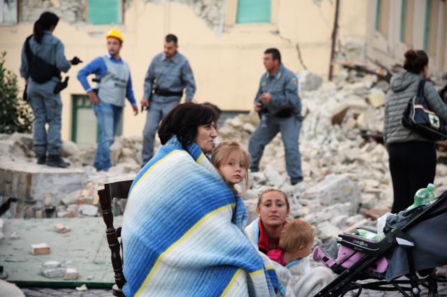 Victims sit among the rubble of a house after a strong heartquake hit Amatrice. (AFP Photo) Victims sit among the rubble of a house after a strong heartquake hit Amatrice. (AFP Photo)