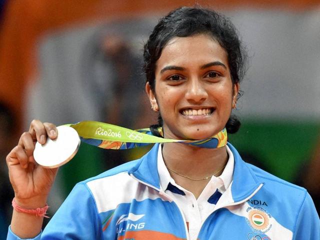 Silver medallist P.V. Sindhu (IND) of India poses with an Indian national flag.(REUTERS)