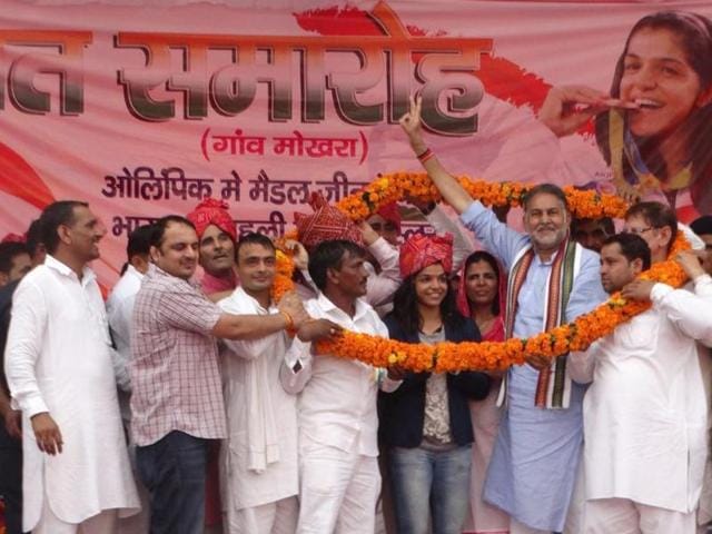 BJP leader and Haryana education minister Ram Bilas Sharma felicitating Sakshi Malik in Mokhra village on Wednesday.(HT Photo) BJP leader and Haryana education minister Ram Bilas Sharma felicitating Sakshi Malik in Mokhra village on Wednesday.(HT Photo)