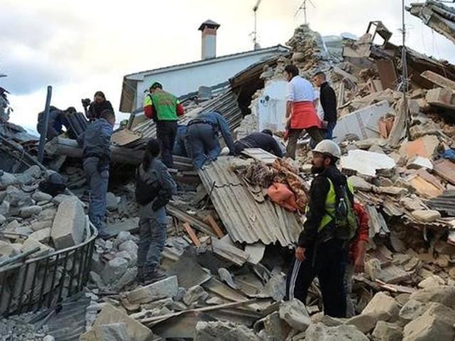 Rescuers search for survivors at a collapsed house after a powerful earthquake hit central Italy. (Reuters Photo)