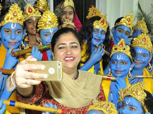 A teacher clicks herself with children dressed as Lord Krishna in Patiala. (Bharat Bhushan/HT Photo)