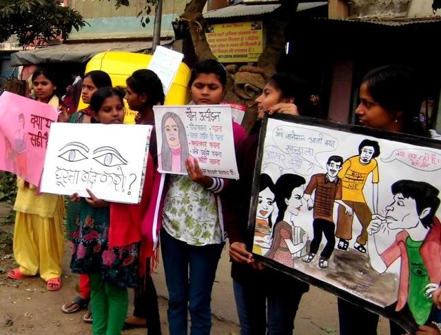 Girls holding posters with messages against the social evils of sexual harassment.