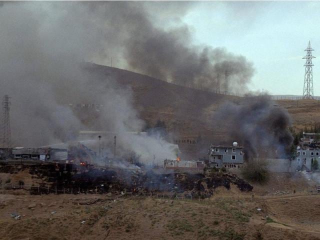 Smoke rises the destroyed police headquarters on Friday in Cizre, southeastern Turkey after a suicide truck bombing killed eleven Turkish police officers and injured 78 people.(AFP)