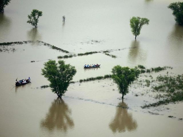 Villagers use boats to cross a flooded area on the outskirts of Allahabad.(AFP File) Villagers use boats to cross a flooded area on the outskirts of Allahabad.(AFP File)