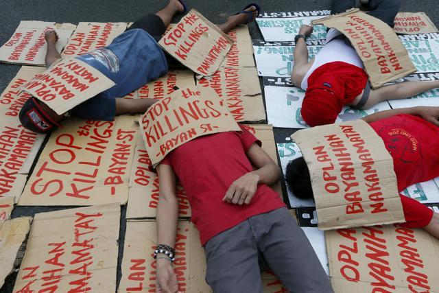 Protesters stage a "die-in" to dramatize the rising number of extra-judicial killings related to Philippine President Rodrigo Duterte's "War on Drugs" , in front of the armed forces headquarters in suburban Quezon city northeast of Manila. (AP)