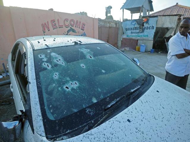 A man stands next to a car with impacts of bullets next to the beach restaurant in the capital Mogadishu. (AFP Photo) A man stands next to a car with impacts of bullets next to the beach restaurant in the capital Mogadishu. (AFP Photo)