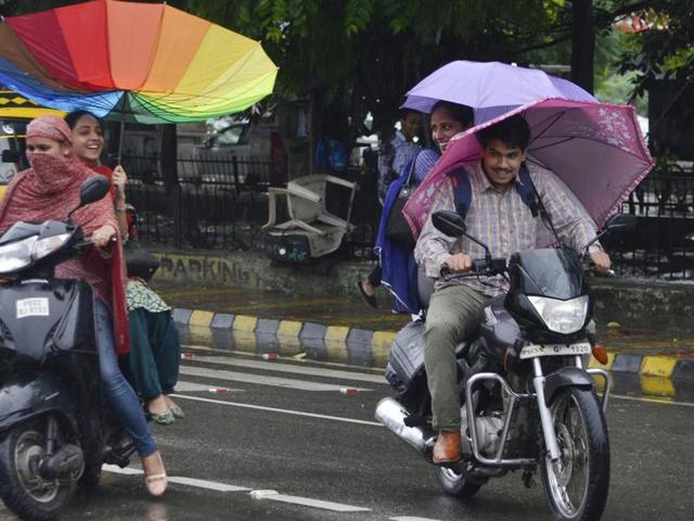 Commuters in the rain in Amritsar on Saturday. (Sameer Sehgal/HT Photo)