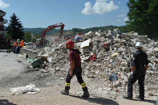 Rescue and emergency services personnel walk next to an excavator used to search for victims under the remains of a building in the damaged central Italian village of Amatrice on Friday, two day after a 6.2-magnitude earthquake struck the region killing some 267 people. (AFP) Rescue and emergency services personnel walk next to an excavator used to search for victims under the remains of a building in the damaged central Italian village of Amatrice on Friday, two day after a 6.2-magnitude earthquake struck the region killing some 267 people. (AFP)