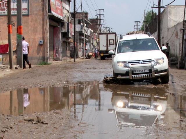 A vehicle stuck on a potholed road in Kanganwal area(JS Grewal/HT Photo) A vehicle stuck on a potholed road in Kanganwal area(JS Grewal/HT Photo)