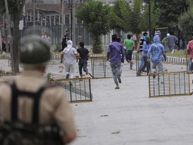 Policeman chase protesters following the killing of teenager Irfan Ahmed by security forces in downtown area of Srinagar, J-K, on Monday,August 22,2016. Kashmir Valley has been witnessing violent protests since July 8 when militant commander Burhan Wani was killed. (Waseem Andrabi / HT Photo) Policeman chase protesters following the killing of teenager Irfan Ahmed by security forces in downtown area of Srinagar, J-K, on Monday,August 22,2016. Kashmir Valley has been witnessing violent protests since July 8 when militant commander Burhan Wani was killed. (Waseem Andrabi / HT Photo)