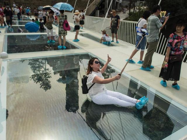 A tourist uses a selfie stick to take a photograph on the bridge. According to reports, a selfie-stick may be one of the few things restricted to be carried on the bridge. (AFP) 