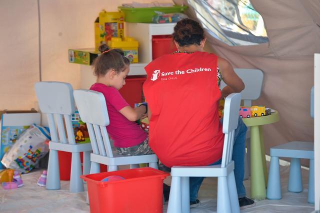 A member of NGO Save the Children seats next to a child in a tent inside a camp at the damaged central Italian village of Amatrice. (AFP Photo) A member of NGO Save the Children seats next to a child in a tent inside a camp at the damaged central Italian village of Amatrice. (AFP Photo)