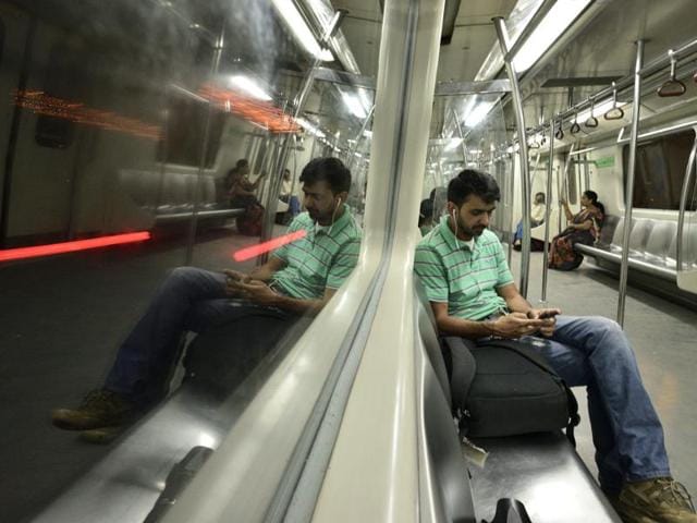 A commuter listens to music on his phone on the last train on the Blue Line, which runs from Dwarka to Vaishali in New Delhi on Monday. (arun sharma/ht) 