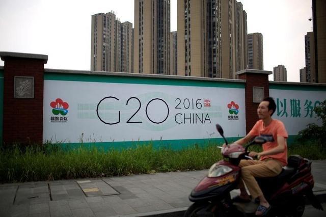 A man rides an electronic bike past a billboard for the upcoming G20 summit in Hangzhou, Zhejiang province of China (Reuters ) A man rides an electronic bike past a billboard for the upcoming G20 summit in Hangzhou, Zhejiang province of China (Reuters )