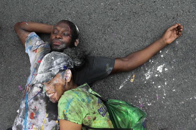 Revellers covered in paint, a traditional way of starting the carnival, pose on the first day of the Notting Hill Carnival (AFP)
