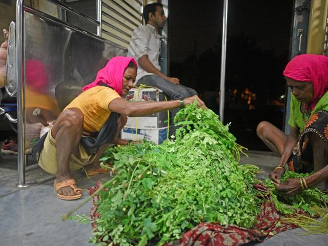 Vegetable vendors sift through their wares inside the first local train from Karjat to Mumbai on Thursday. (Pratik Chorge/HT ) 