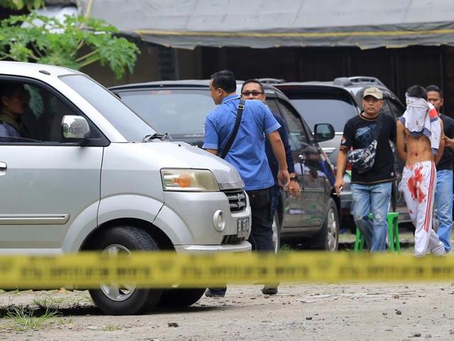 Indonesian policemen guard a blindfolded suspect who attacked a priest in Medan. (AFP Photo) Indonesian policemen guard a blindfolded suspect who attacked a priest in Medan. (AFP Photo)
