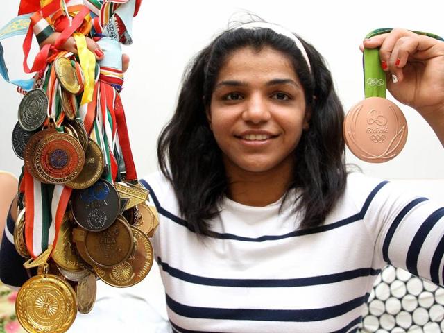 Sakshi Malik holding all her previous won medals in one hand and her recent Olympic bronze in the other.(Manoj Dhaka/HT Photo) Sakshi Malik holding all her previous won medals in one hand and her recent Olympic bronze in the other.(Manoj Dhaka/HT Photo)