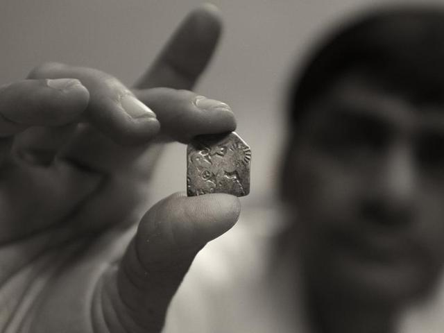 A punched-marked coin dating back to the Mauryan Empire is held up by Anwar Aziz , who has more than three thousand coins in his collection. Mauryan err coins were made of silver of standard weight and had irregular shapes. (Virendra Singh Gosain/HT PHOTO) A punched-marked coin dating back to the Mauryan Empire is held up by Anwar Aziz , who has more than three thousand coins in his collection. Mauryan err coins were made of silver of standard weight and had irregular shapes. (Virendra Singh Gosain/HT PHOTO)