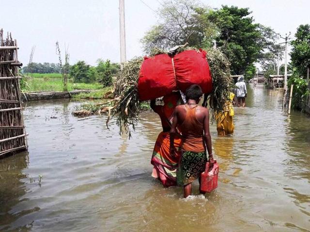 Villagers wade though a flooded area in Katihar district of Bihar on Sunday. (PTI Photo) Villagers wade though a flooded area in Katihar district of Bihar on Sunday. (PTI Photo)