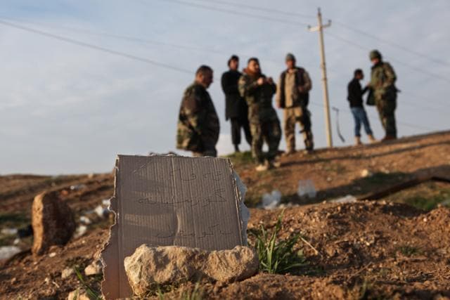 In this Dec. 22, 2014, file photo, Kurdish Peshmerga forces inspect a site marked in Kurdish with a sign reading, "Kurdish mass grave,” in Hardan village in northern Iraq. A handful of Yazidis who fled this tiny northern Iraqi hamlet when Islamic State militants overran it in August 2014 have returned after Kurdish fighters drove out the extremists. (AP) In this Dec. 22, 2014, file photo, Kurdish Peshmerga forces inspect a site marked in Kurdish with a sign reading, "Kurdish mass grave,” in Hardan village in northern Iraq. A handful of Yazidis who fled this tiny northern Iraqi hamlet when Islamic State militants overran it in August 2014 have returned after Kurdish fighters drove out the extremists. (AP)