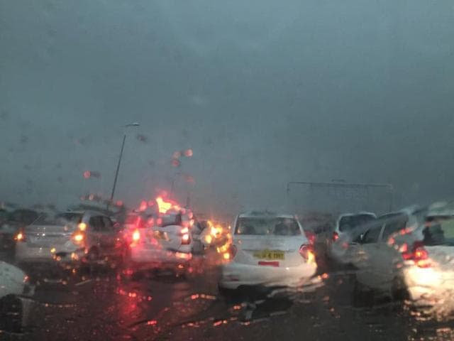 As the skies become dark and rains lash Gurgaon on Wednesday morning, vehicles keep their headlights on.(Photo: Twitter)