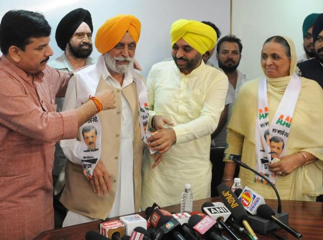 Aam Aadmi Party leaders Sanjay Singh and Bhagwant Mann felicitating Harmail Singh Tohra (2nd from left) and his wife Kuldeep Kaur as the couple joined the party in Chandigarh on Tuesday.(Anil Dayal/HT Photo)