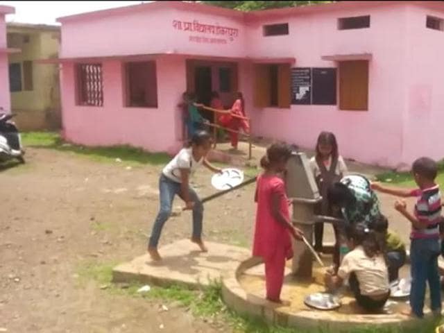 Kids wash their utensils after the mid-day meal in their school in Agar district.