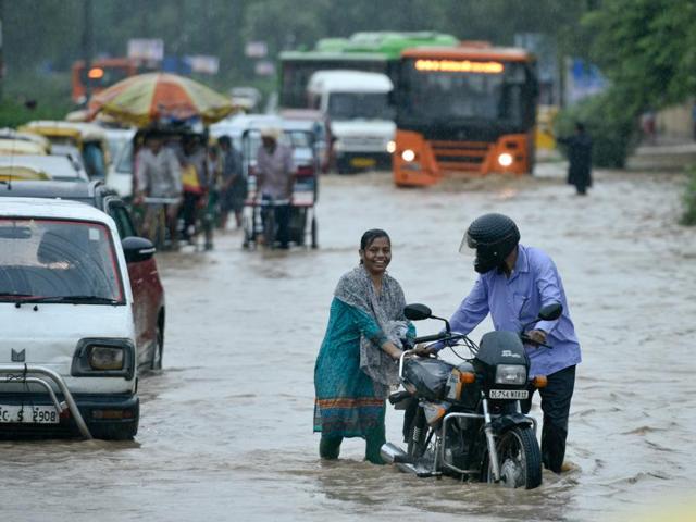 The downpour, coupled with strong winds and lightning for more than four hours in the morning, flooded roads across Delhi with hundreds of people stranded at bus stops and Metro stations. A couple in Turkman Gate pushes their bike after being caught in the rain. (Arun Sharma/HT PHOTO) The downpour, coupled with strong winds and lightning for more than four hours in the morning, flooded roads across Delhi with hundreds of people stranded at bus stops and Metro stations. A couple in Turkman Gate pushes their bike after being caught in the rain. (Arun Sharma/HT PHOTO)