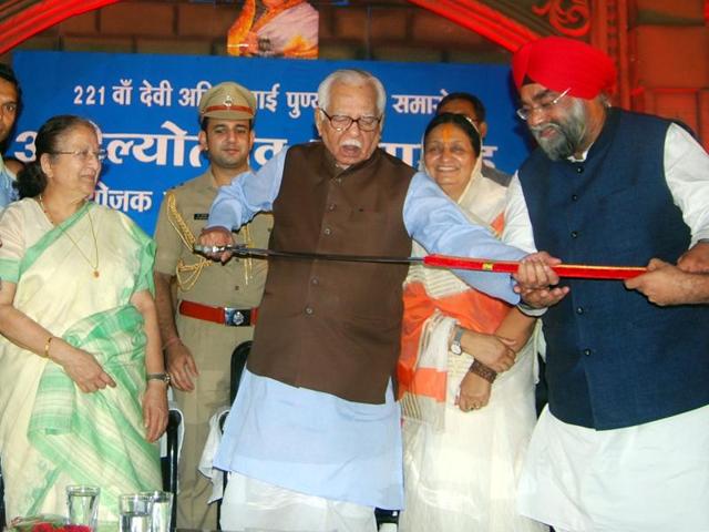 UP guv Ram Naik, besides Lok Sabha Spreaker Sumitra Mahajan, holds a sword gifted by Sikhs in Indore on Wednesday.(Arun Mondhe/ HT Photo)